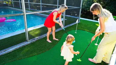 two women and a little girl playing a game of golf at Hidden Miami Oasis Heated Pool and Games in Golden Glades