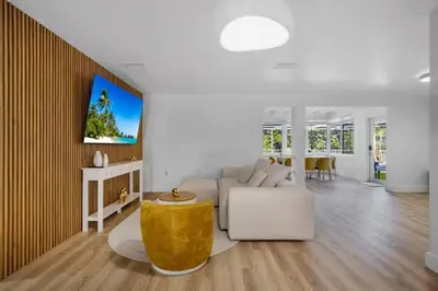 a living room with a couch and a tv on a wall at Hidden Miami Oasis Heated Pool and Games in Golden Glades
