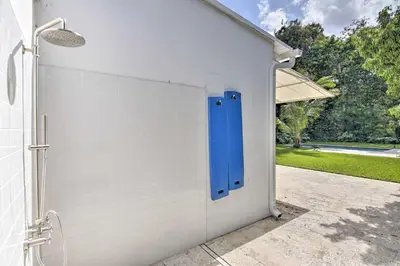a white garage with a blue door in it at Biscayne Park Urban Oasis with Lush Backyard! in Biscayne Park