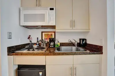 a kitchen with a sink and a microwave at Arya Hotel Studio Views plus Kitchenette plus Parking in Miami