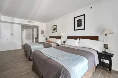 a hotel room with two beds and a desk at Arya Hotel Studio Views plus Kitchenette plus Parking in Miami