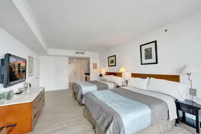 a hotel room with two beds and a television at Arya Hotel Studio Views plus Kitchenette plus Parking in Miami