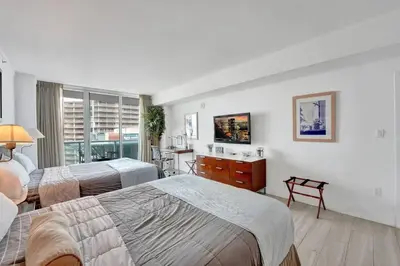 a bedroom with two beds and a desk and a window at Arya Hotel Studio Views plus Kitchenette plus Parking in Miami