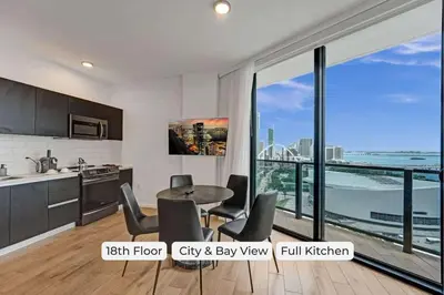 a kitchen with a table and chairs and a large window at Miami 3BR Retreat City and Bay Views in Miami