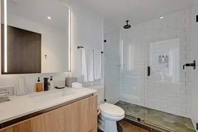 a white bathroom with a toilet and a shower at Miami 3BR Retreat City and Bay Views in Miami