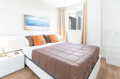 a white bedroom with a large bed with orange pillows at Lovely 2 bedrooms 2 bathrooms Apt, Sleeps 4, Split King bed, Free Parking, Pet OK in Miami