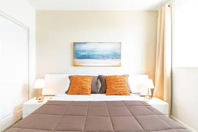 a bedroom with a white bed with orange pillows at Lovely 2 bedrooms 2 bathrooms Apt, Sleeps 4, Split King bed, Free Parking, Pet OK in Miami