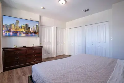 a bedroom with a bed and a tv on the wall at Lovely 2 bedrooms 2 bathrooms Apt, Sleeps 4, Split King bed, Free Parking, Pet OK in Miami