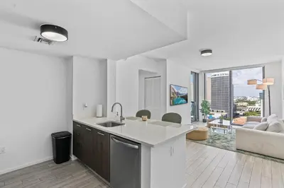 a kitchen with a sink and a living room at Downtown Miami Luxe Studio Suite in Miami