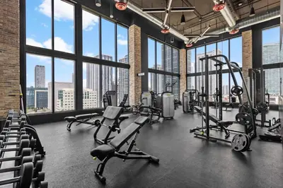 a gym with treadmills and cardio equipment in a building with windows at Downtown Miami Luxe Studio Suite in Miami