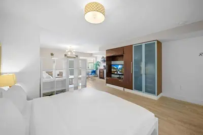 a white bedroom with a large bed and a television at Ocean Drive Studio - Walk to the beach Rooftop Pool in Miami Beach