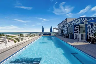 a swimming pool with the ocean in the background at Ocean Drive Studio - Walk to the beach Rooftop Pool in Miami Beach