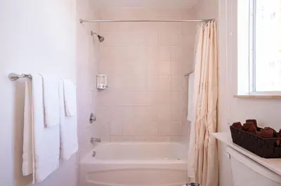 a white bathroom with a tub and a shower at Large Apt, Parking, Split King Bed, Washer & Dryer in Miami