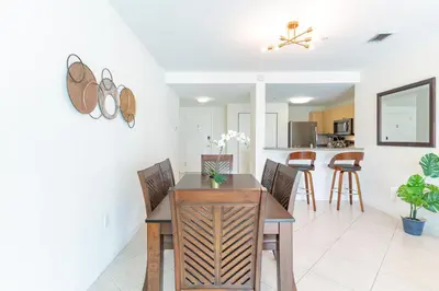 a dining room and kitchen with a table and chairs at Large Apt, Parking, Split King Bed, Washer & Dryer in Miami