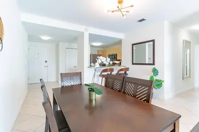 a dining room and living room with a table and chairs at Large Apt, Parking, Split King Bed, Washer & Dryer in Miami