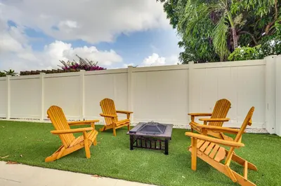 four wooden chairs and a table in a yard at Backyard Oasis Fort Lauderdale Home Near Beach in Fort Lauderdale