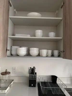 a kitchen with white bowls and plates on shelves at Stylish 2BR Quadro Luxe Stay in Design District in Miami