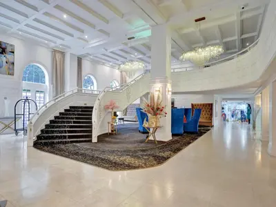 a lobby with a staircase and blue chairs at Luxury Beachside 3BR 3BA Condo Resort Amenities Pools Gym and Sauna 620 in Miami Beach