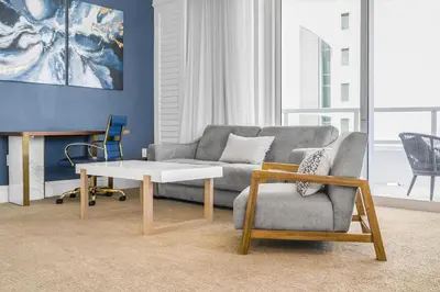 a living room with a couch and a table and a chair at FontaineBleau Suite Ocean View in Miami Beach