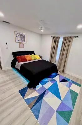 a bedroom with a bed and a colorful rug at Serene 3-Bedroom renovated house with AC in Fort Lauderdale in Fort Lauderdale