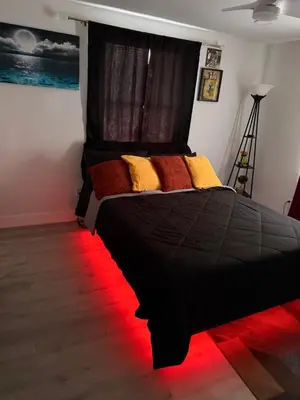 a bedroom with a black bed with a red light at Serene 3-Bedroom renovated house with AC in Fort Lauderdale in Fort Lauderdale