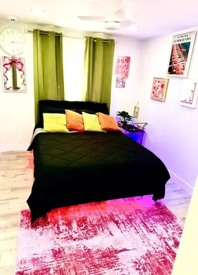 a bedroom with a black bed with colorful pillows at Serene 3-Bedroom renovated house with AC in Fort Lauderdale in Fort Lauderdale
