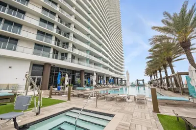 a pool at a hotel with palm trees and a building at LYFE Resort Ocean View Penthouse in Hollywood
