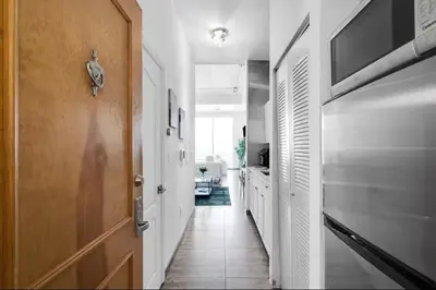 a hallway with white walls and a wooden door at Cozy Studio in Brickell free parking in Miami