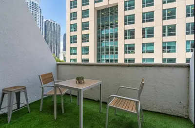 a table and chairs on a balcony with a building at Cozy Studio in Brickell free parking in Miami