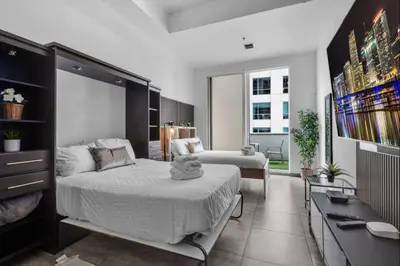 a bedroom with a bed and a living room at Cozy Studio in Brickell free parking in Miami