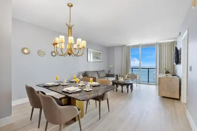 a dining room and living room with a table and chairs at W hotel High end ocean view 2 bedroom at icon brickell in Miami