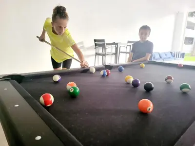 two children playing with a pool table at Luxury Beach & City View Condo 5 min walk to beach in Sunny Isles Beach