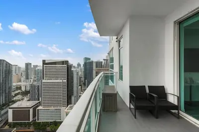 a balcony with two chairs and a view of a city at 47th-Floor Brickell Condo with City Views and Pool in Miami