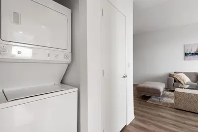 a kitchen with a white refrigerator and a living room at 47th-Floor Brickell Condo with City Views and Pool in Miami
