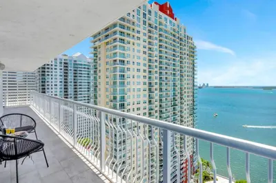 a balcony with a view of the ocean and a tall building at Stylish Renovated 3BR Condo Bay Views plus Parking in Miami