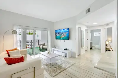 a white living room with a couch and a table at Chic 2BR Edgewater Condo with Views plus Balcony in Miami
