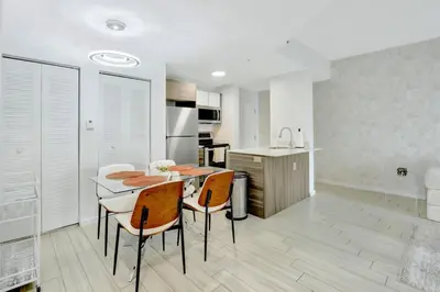 a kitchen and dining room with a table and chairs at Chic 2BR Edgewater Condo with Views plus Balcony in Miami