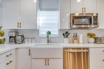 a white kitchen with a sink and a microwave at Fox Garden Luxury Boho Near Downtown & Beach in Fort Lauderdale