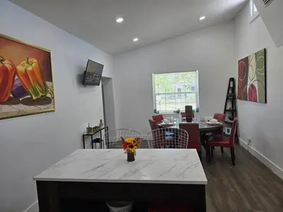 a living room with a table with flowers on it at Little Wynwood Oasis in Miami