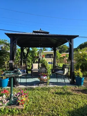 a wooden pergola with chairs and a table at Little Wynwood Oasis in Miami