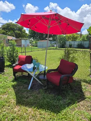 two chairs and a table with a red umbrella at Little Wynwood Oasis in Miami