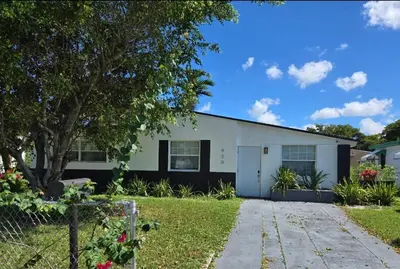 a white house with a tree and a driveway at Little Wynwood Oasis in Miami