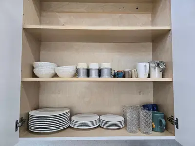 a pantry with plates and bowls on shelves at Little Wynwood Oasis in Miami