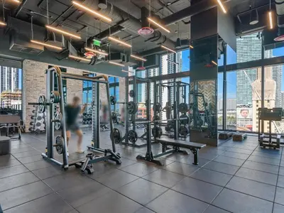 a gym with several tread machines and a person in the background at Top-floor 3BR Stay with skyline views in Miami