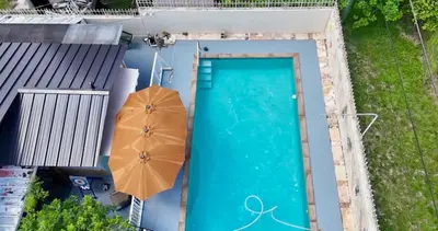 an overhead view of a swimming pool with an umbrella at Love Story Pool House, free parking & BBQ in Miami