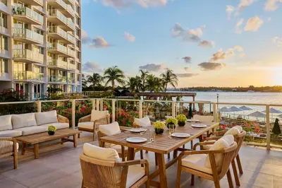 a patio with tables and chairs and a view of the water at 2 King Rooms Mondrian Resort Skyline Bay Balcony in Miami Beach