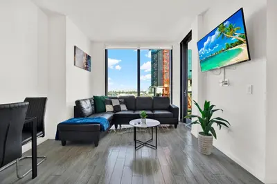 a living room with a couch and a large window at Ocean Front Condo Near Cruise Port, Bayfront Park, plus Free Parking in Miami