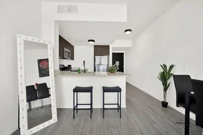 a kitchen with a counter and stools in a room at Ocean Front Condo Near Cruise Port, Bayfront Park, plus Free Parking in Miami