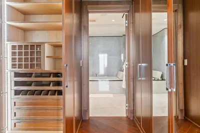a walk in closet with wooden cabinets and a glass door at Luxury 5 Stars - Oceanfront Stay for 4 with World-Class Amenities in Miami Beach