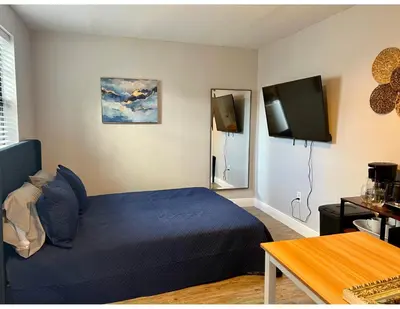 a bedroom with a blue bed and a television at Studios & Coral Gable, close to downtown and airport in Miami